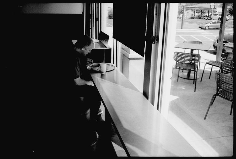 man eating by window